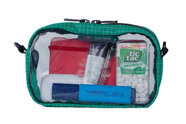 A Kelpie (green with white grid pattern) Halcyon 3D Clear Organizer Cube filled with sundries.